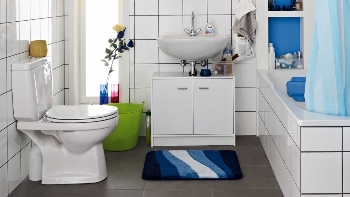 Cluttered bathroom seen before the renovation, with floor-standing WC and exposed cistern Cluttered bathroom seen before the renovation, with floor-standing WC and exposed cistern