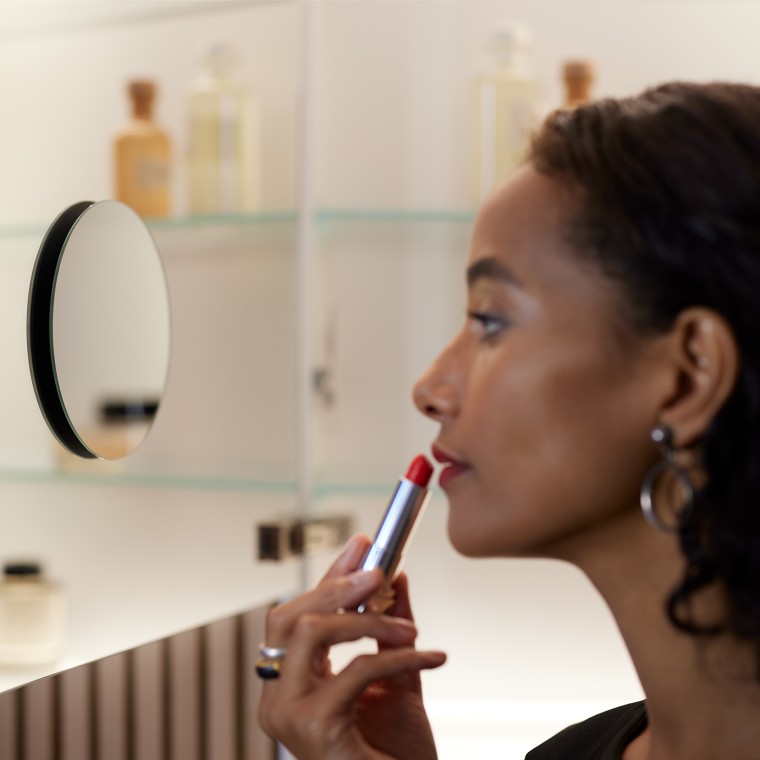 Woman applying make-up in the mirror Woman applying make-up in the mirror