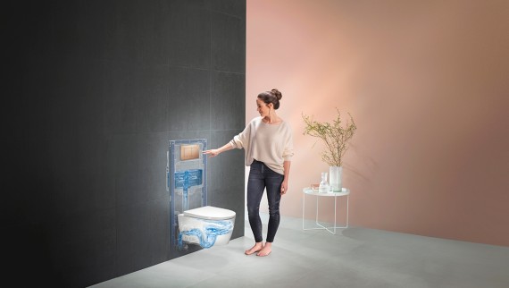 Woman actuating the flush of the Geberit WC system (© Geberit)